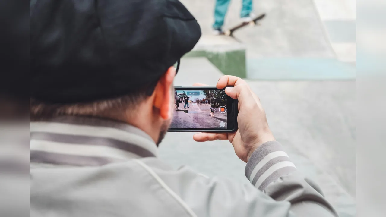 A person filming a scene with a smartphone held sideways