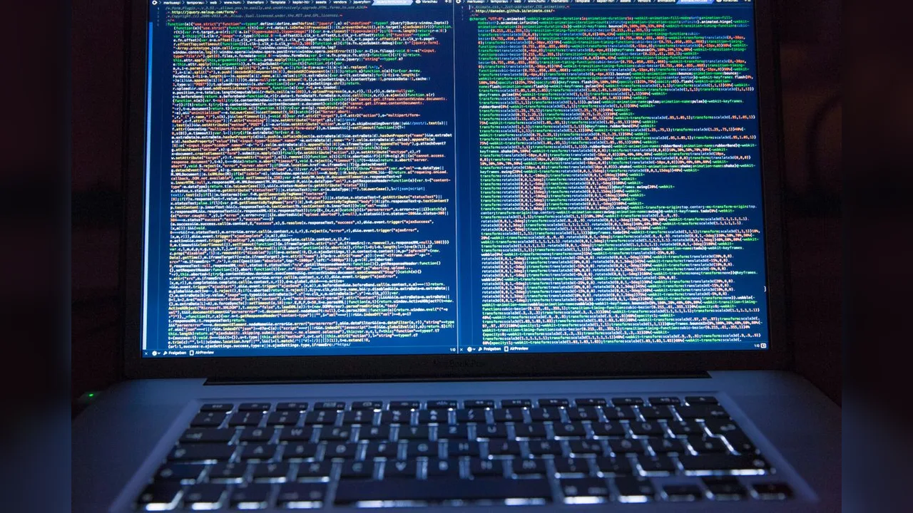 A laptop screen filled with colourful lines of programming code