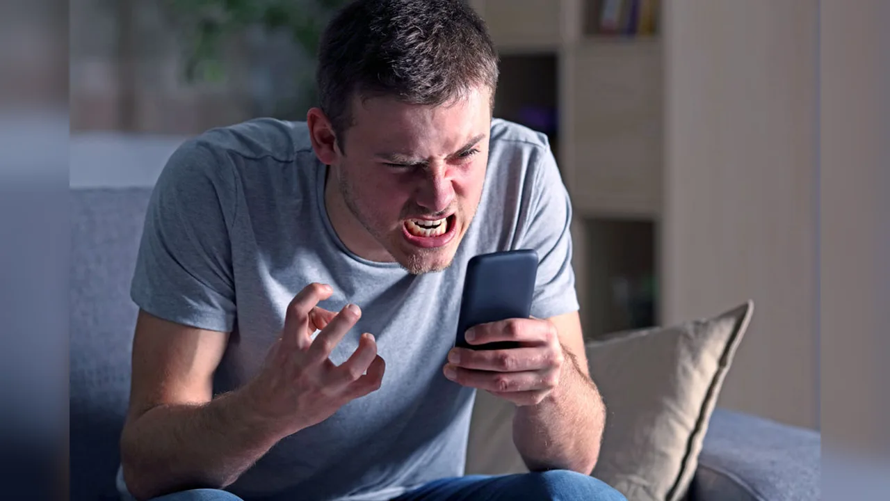 A frustrated man on a sofa gesturing at his smartphone